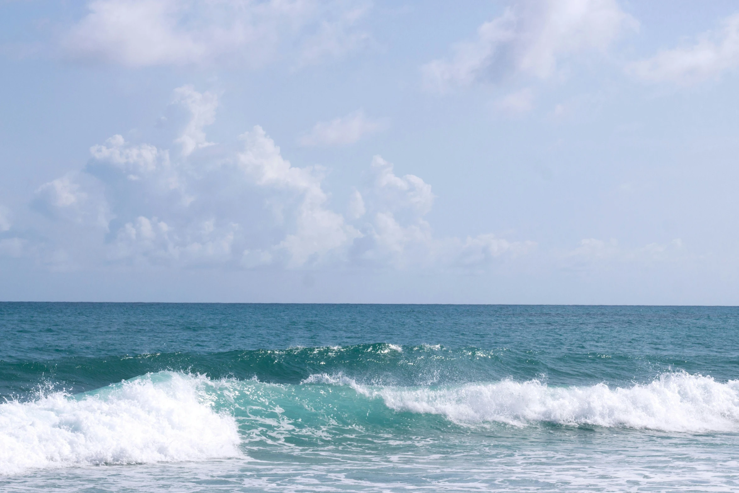 surfer on surfboard riding large and breaking wave