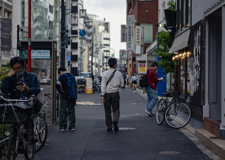 pedestrians walking and bikes are parked on the sidewalk