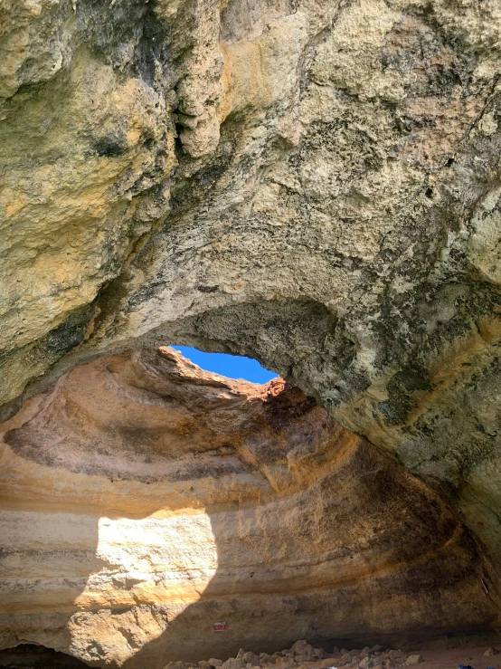 a rocky cave with blue sky inside