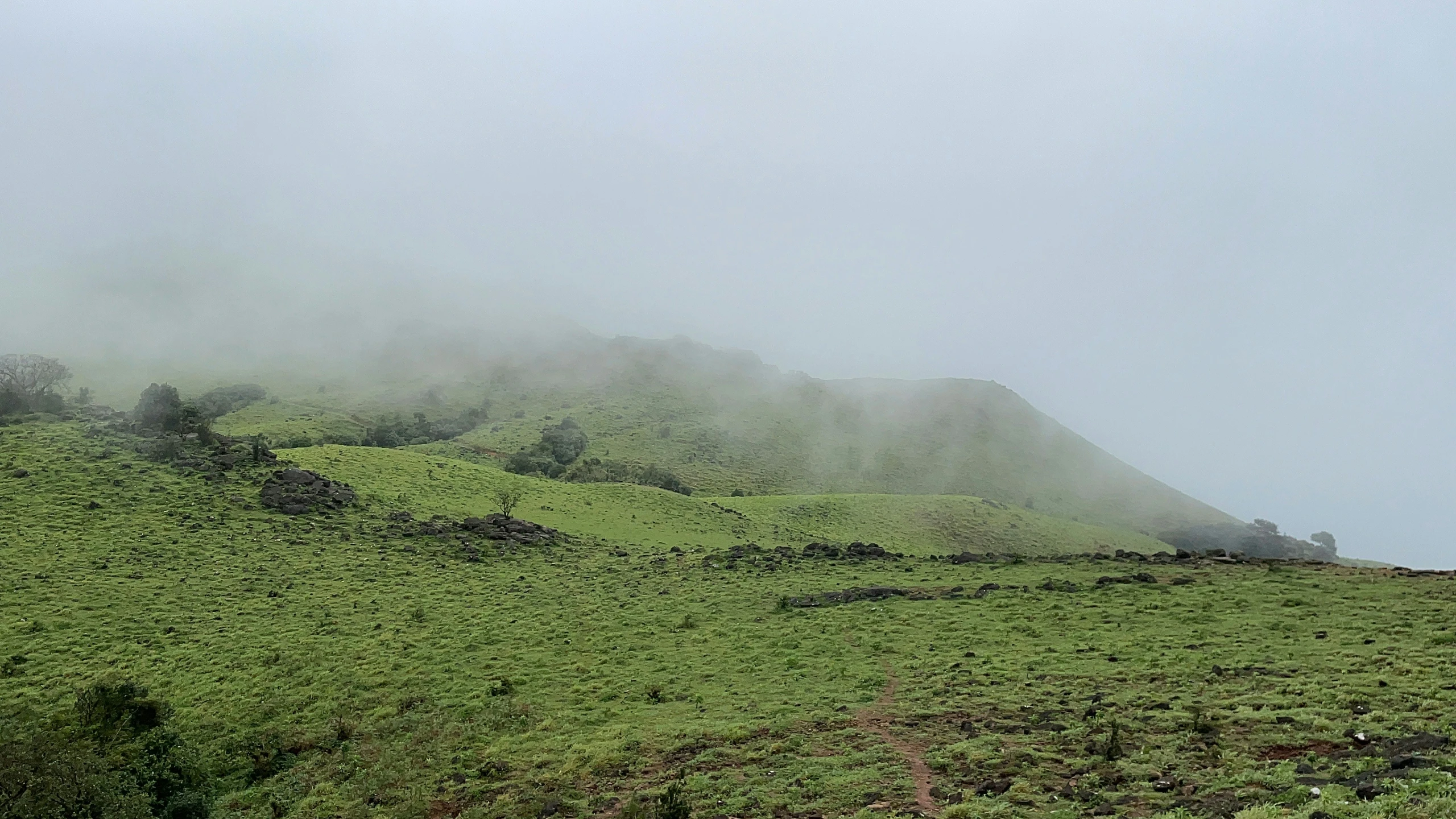 mountains are covered in thick fog on a cloudy day