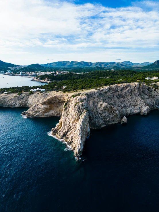 an aerial view of the ocean with a mountain near by