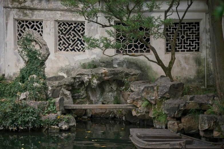 a pond in a building with rocks and water