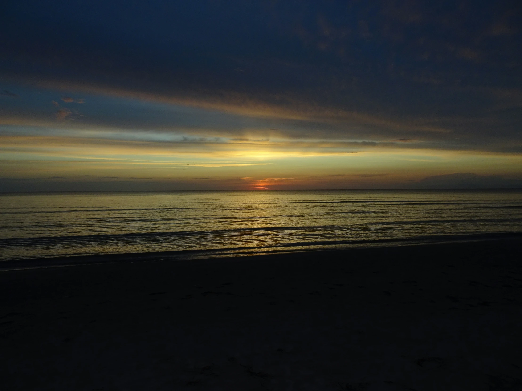 a beautiful sunrise on the beach with blue clouds