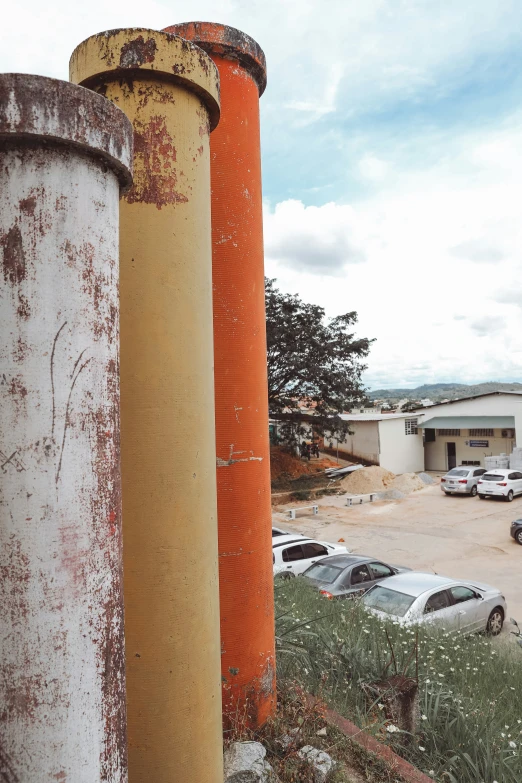 an old rusted metal pipe with cars in the background