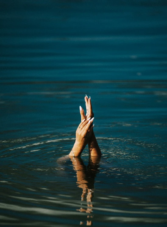 a hand reaching out for soing in the water