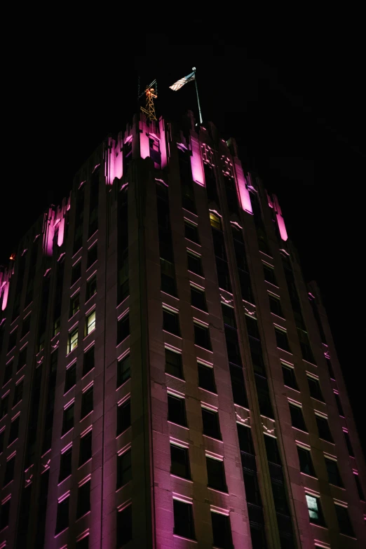 the high building is illuminated with a purple light