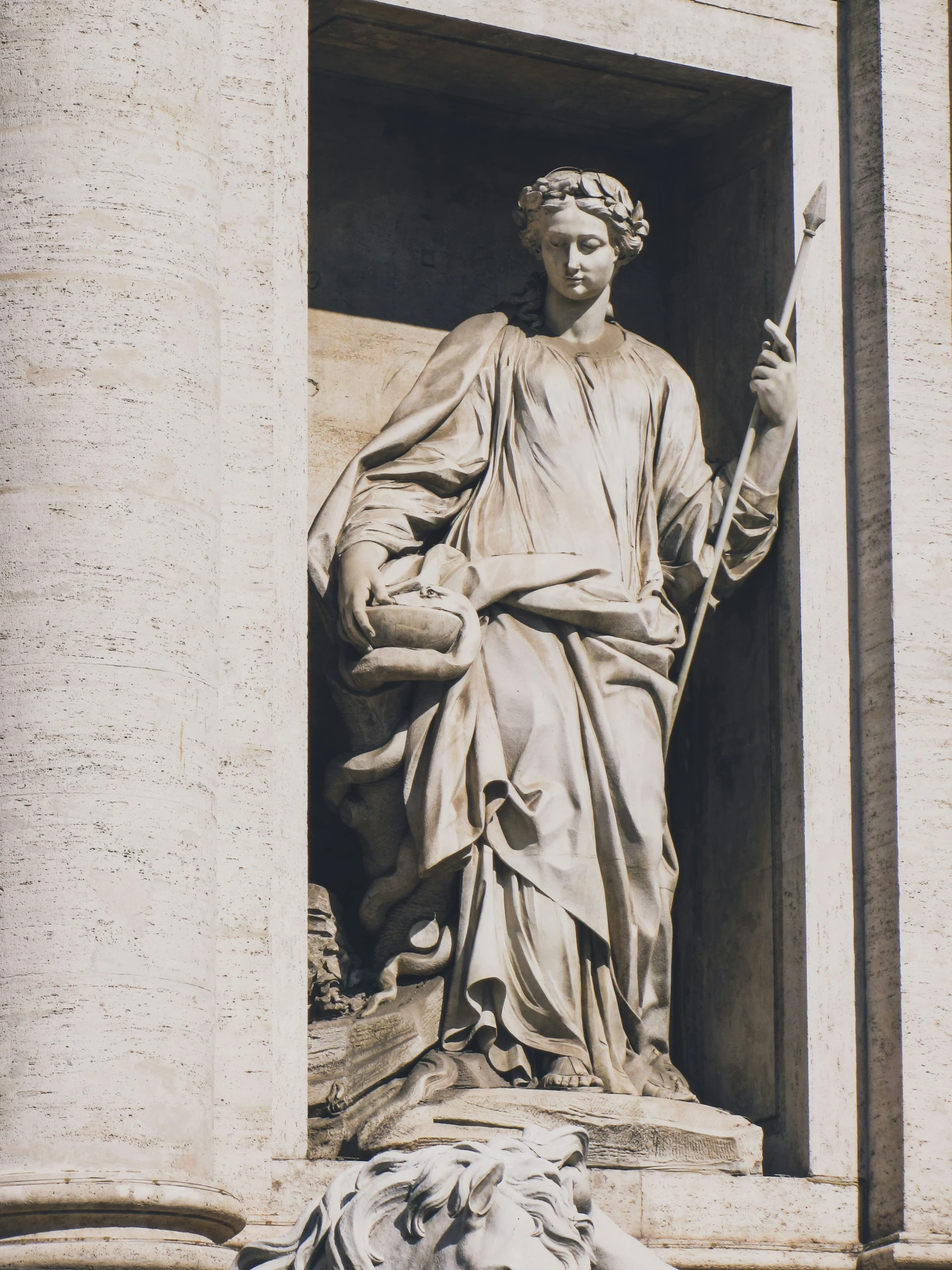 a statue of a man with two arms raised and a cane standing