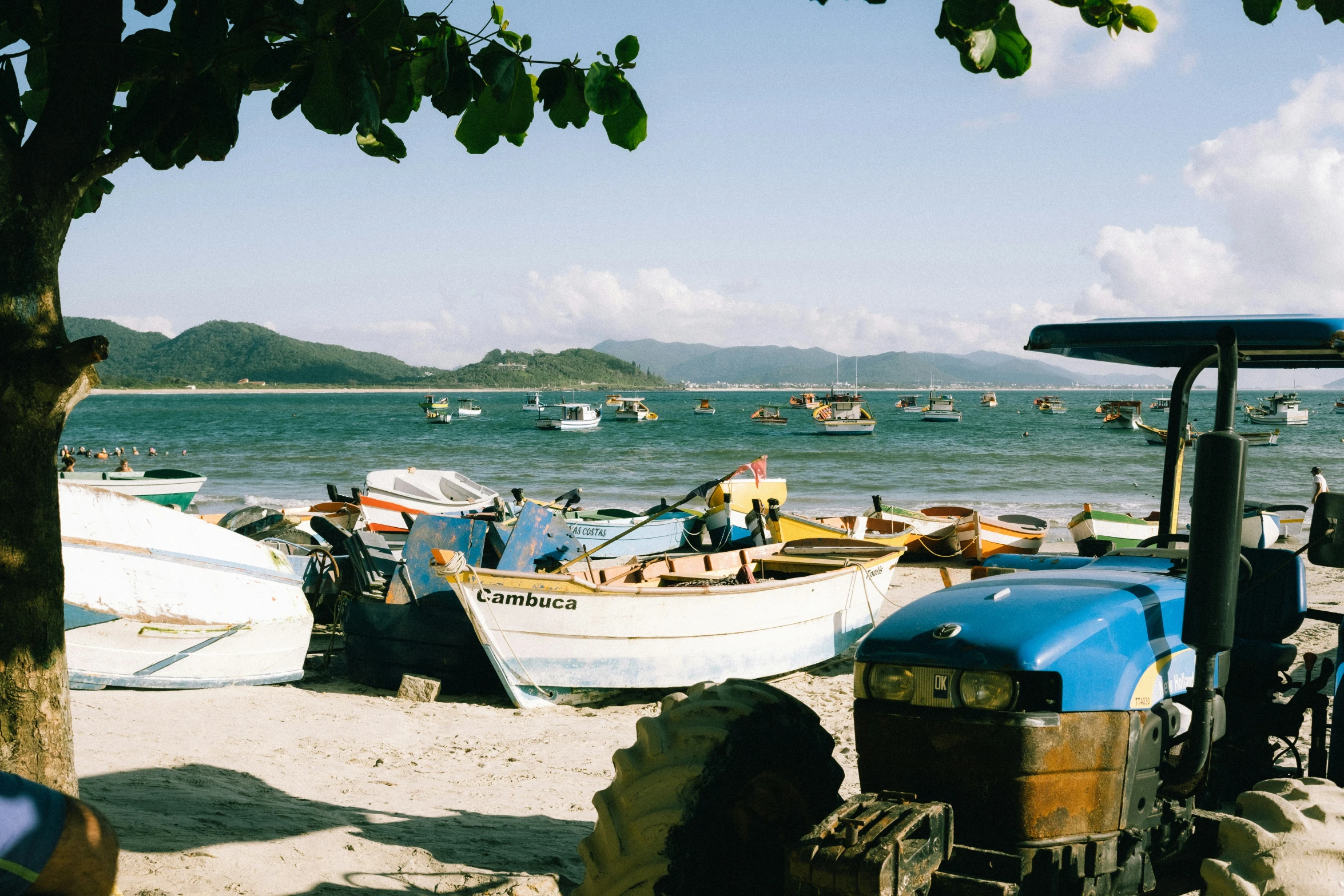 boats moored to the shoreline on a tropical beach