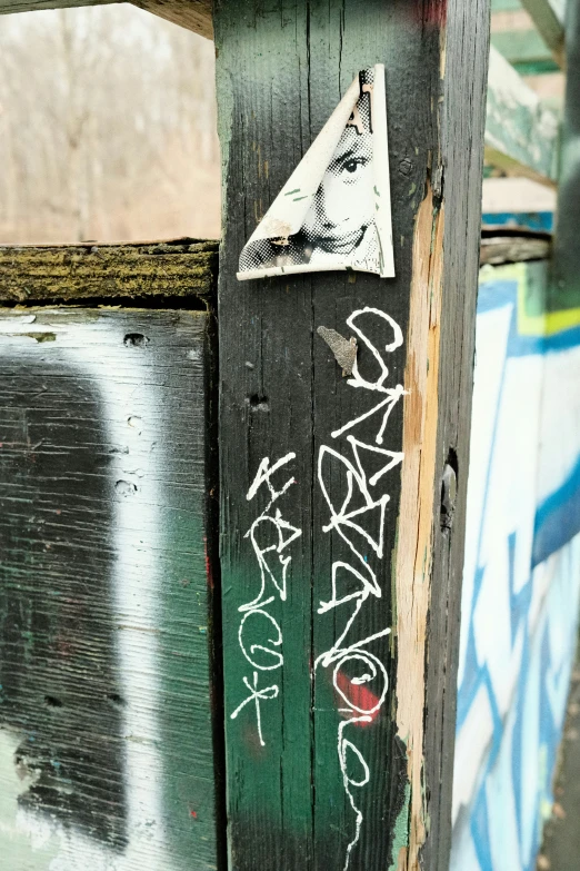 graffiti is on the old wooden fence post