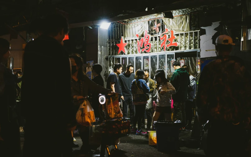 a crowd of people standing around outside a store