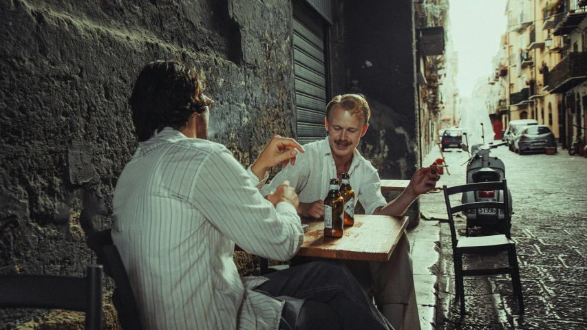 two men are sitting at a table having lunch