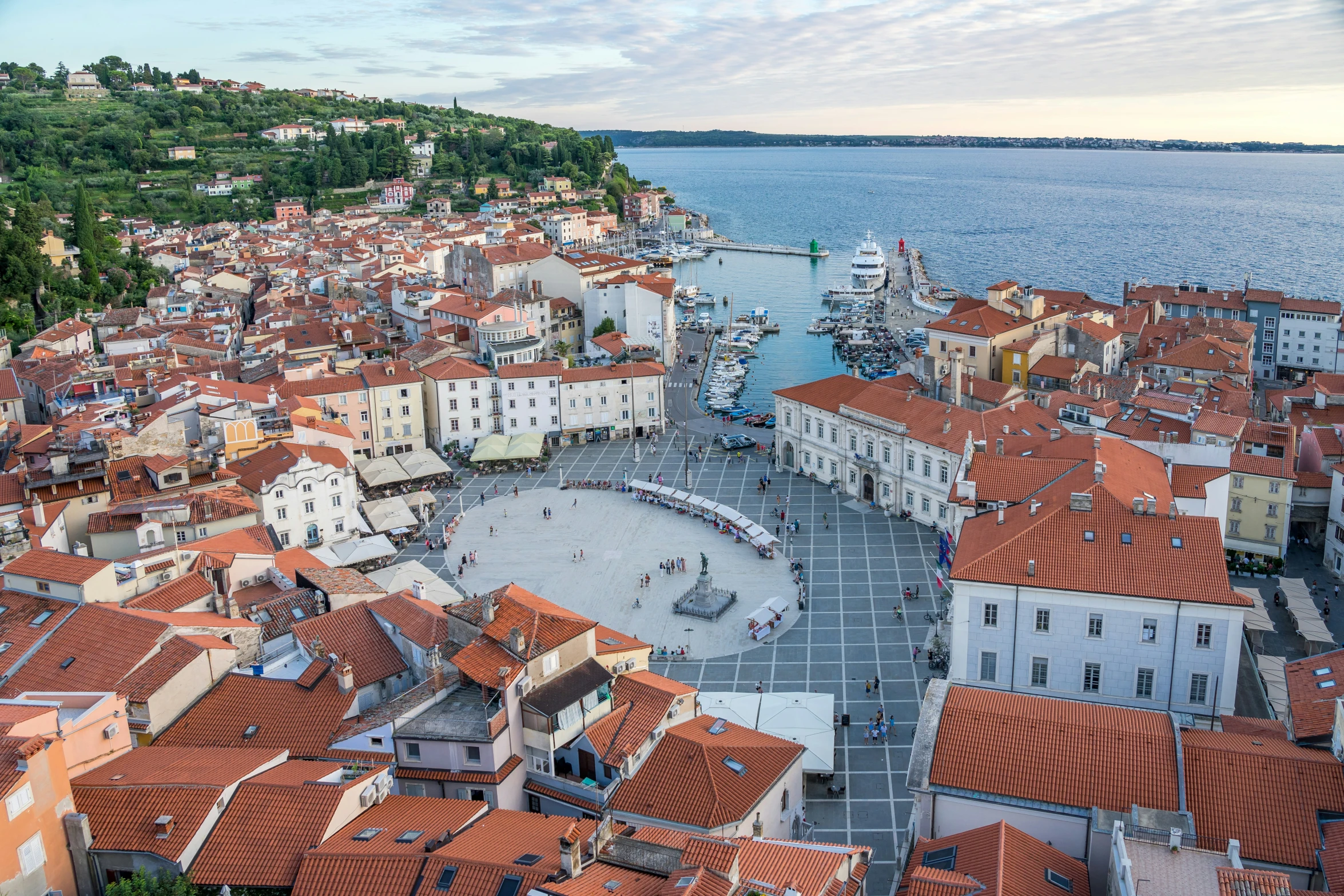 a city skyline overlooking the water with rooftops and water