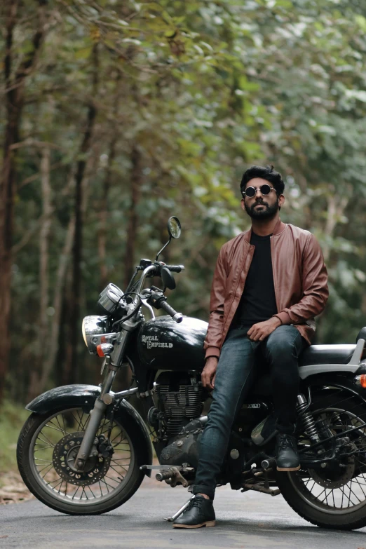 a man sitting on top of a motorcycle on the road