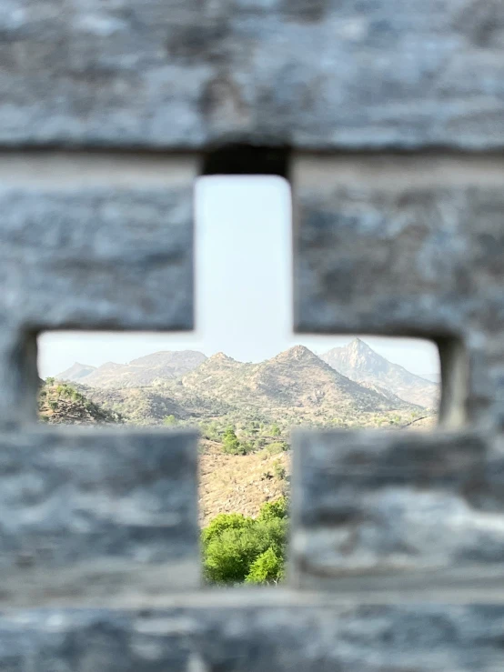 the view through an ironwork gate of a mountain range