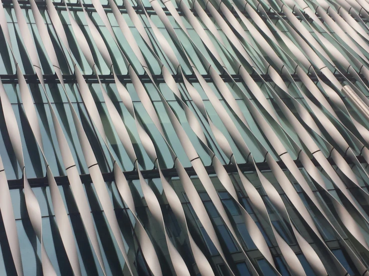 a modern building with curved glass walls and a sky line