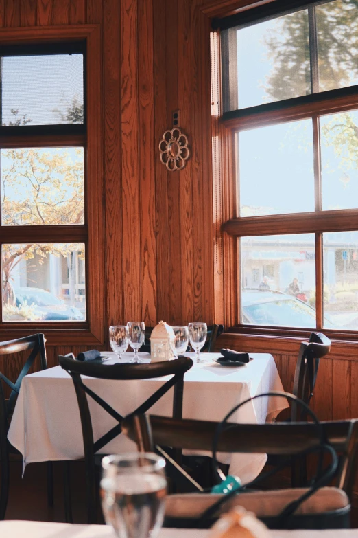 two restaurant tables set with empty glasses and plates