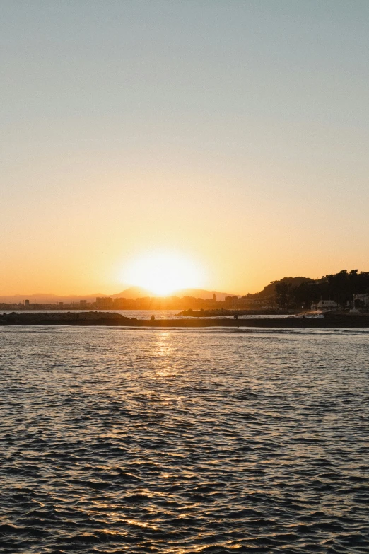 there is an orange sunset over the ocean