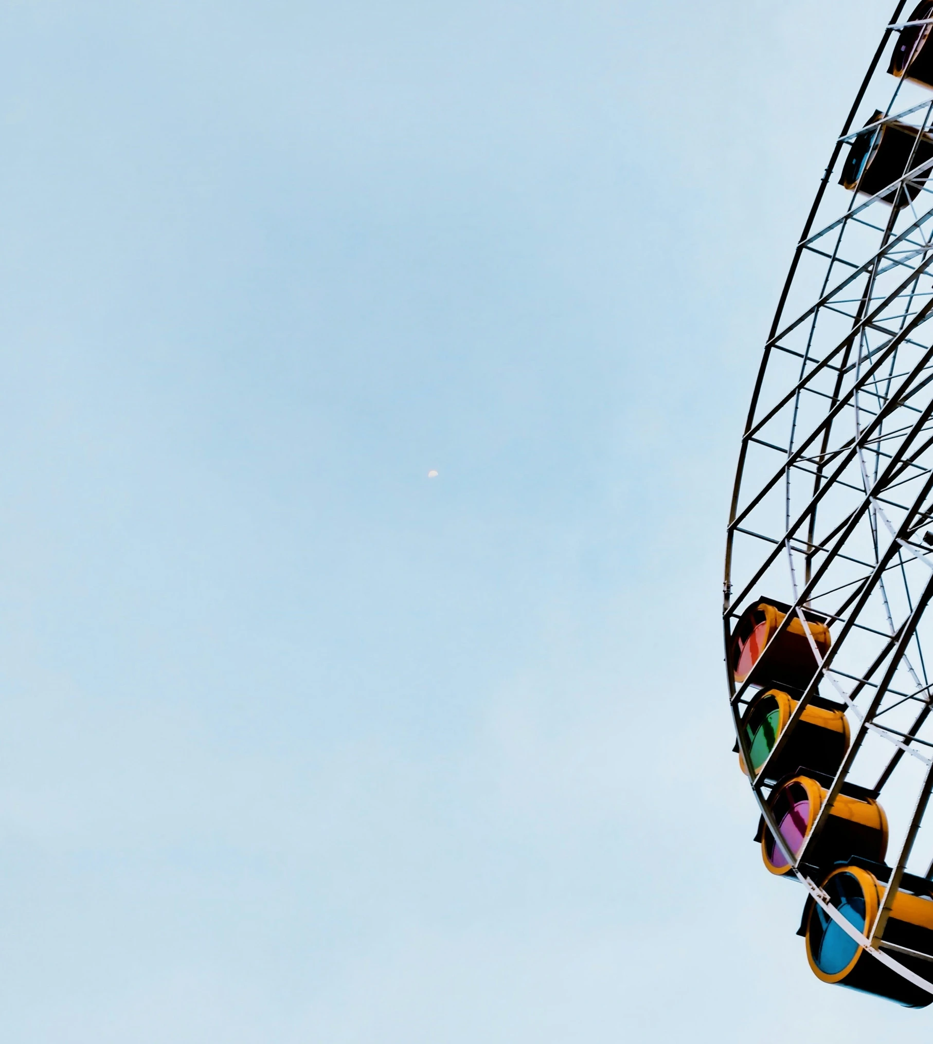 two traffic lights at a carnival against a blue sky