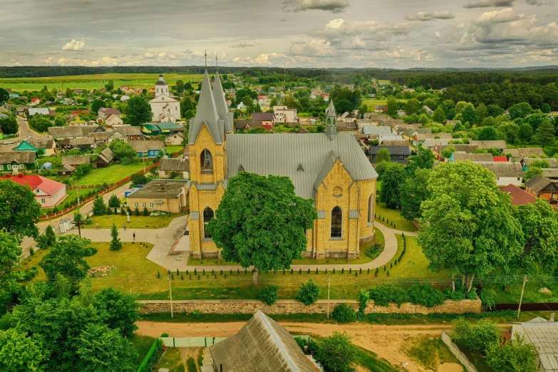 an aerial view of a church near the woods