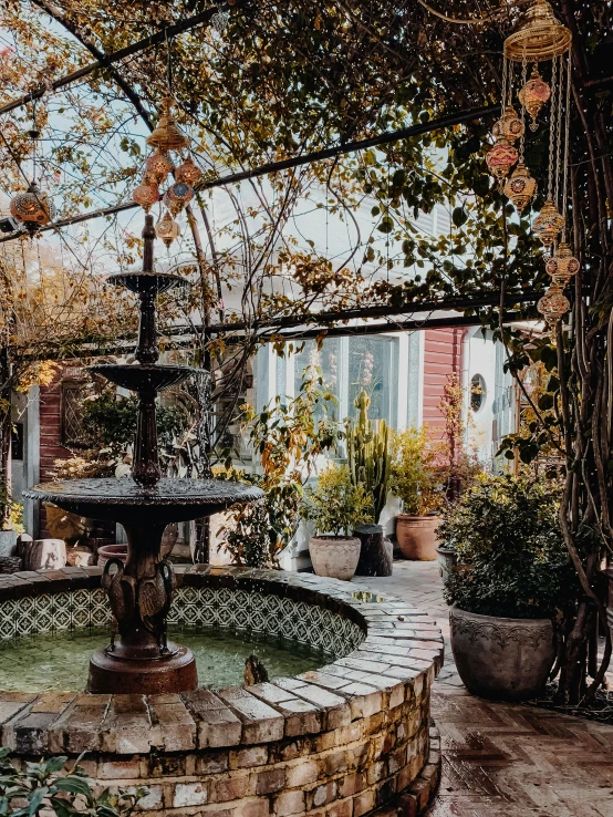 a fountain sitting in the center of a patio next to pots