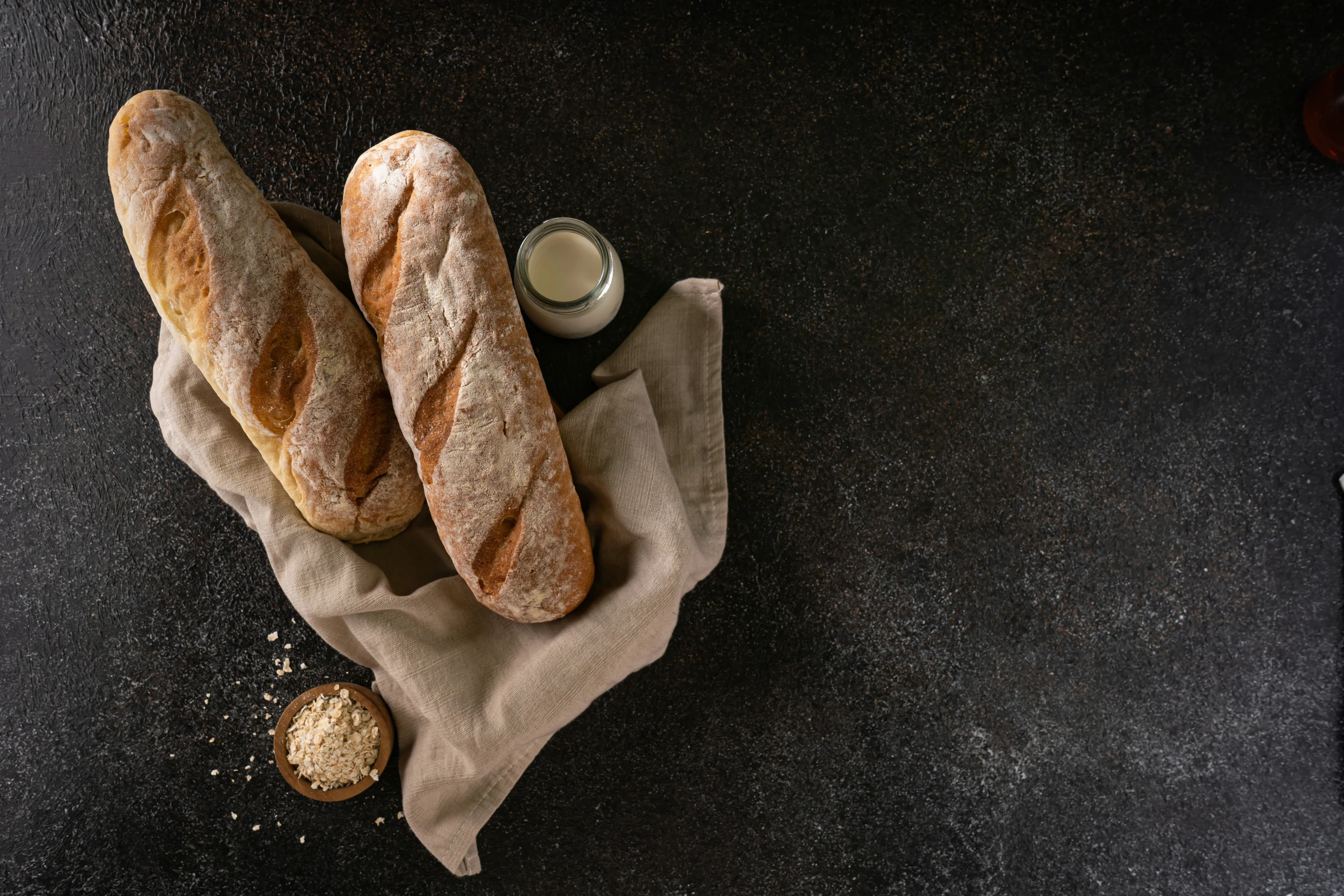 two rolls of bread and a cup on a towel