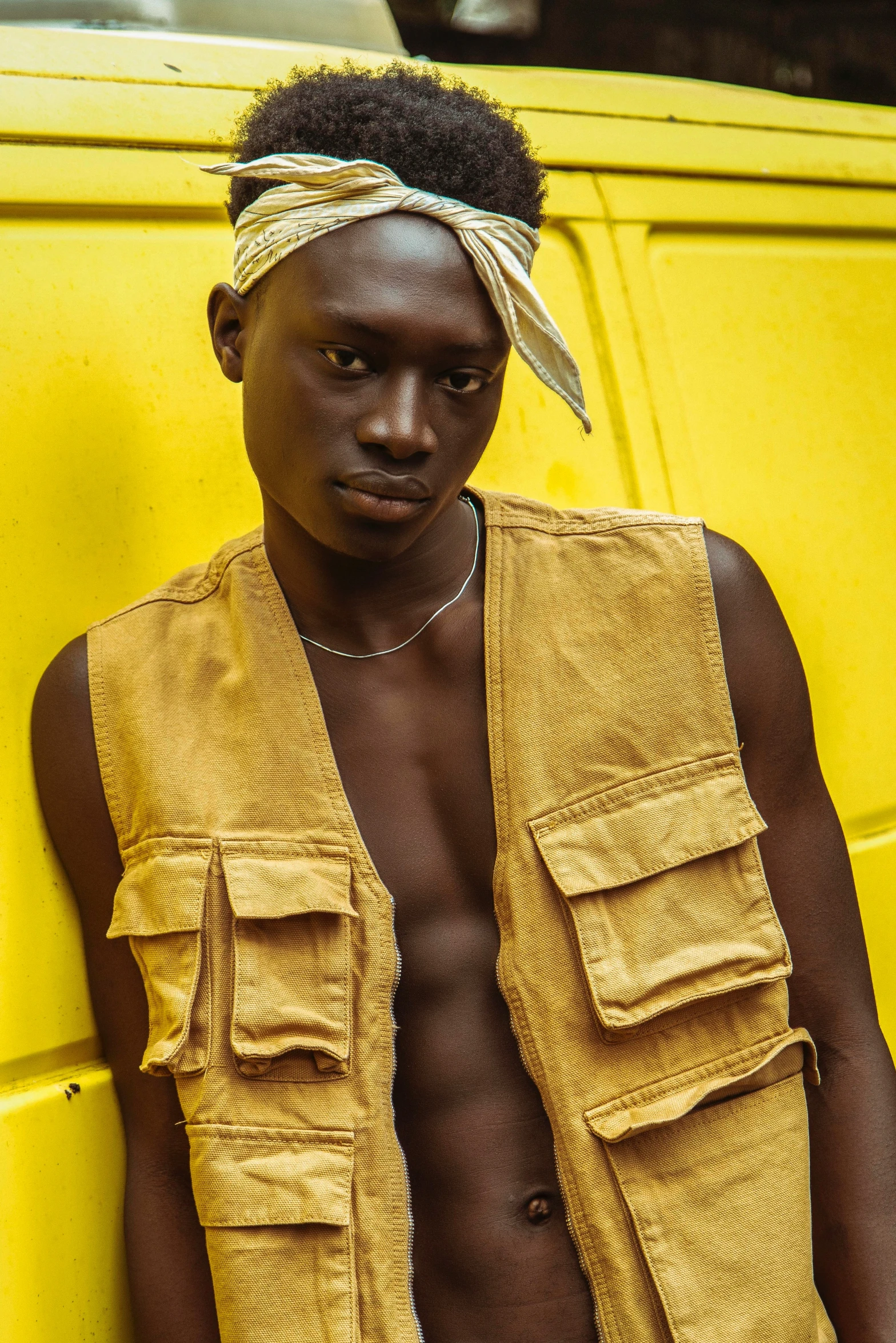 the man is standing in front of a yellow vehicle