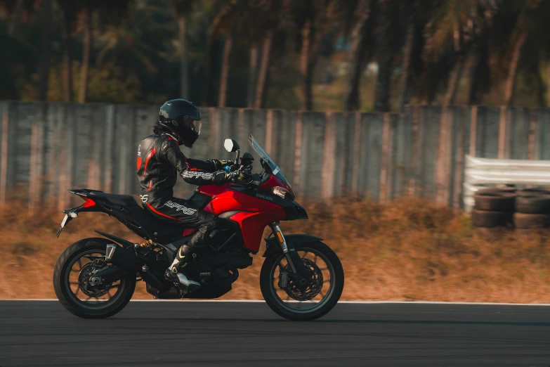 a man that is sitting on a red motorcycle