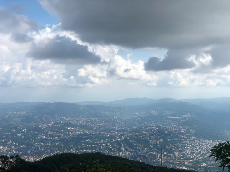 the sky is blue and a lot of clouds are above the mountain