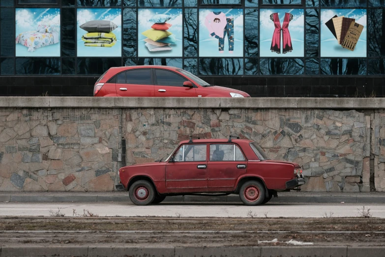 an old car parked near a stone wall