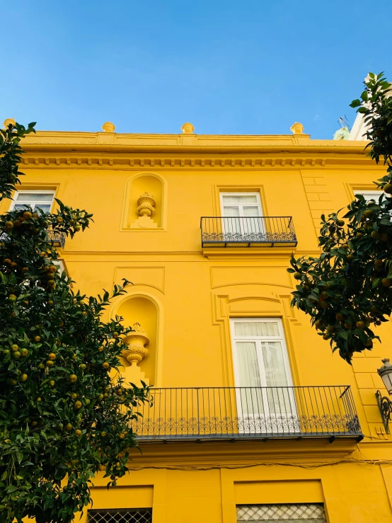 a large yellow building with balconies is pictured