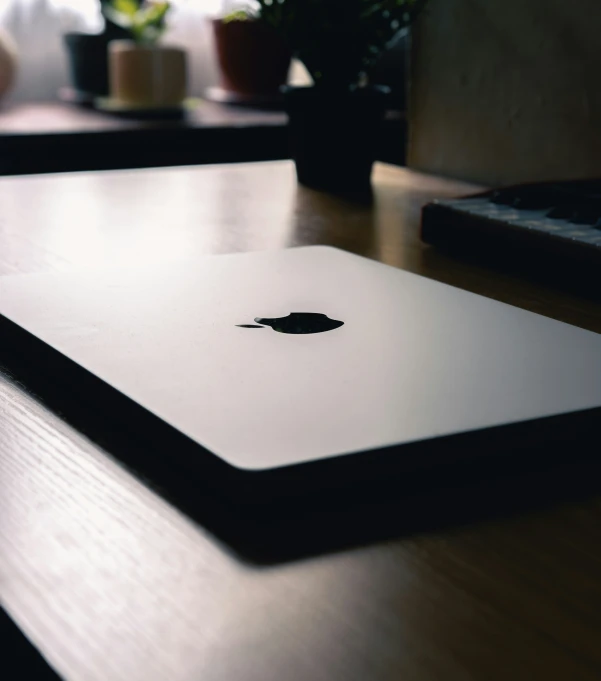 a small, round, apple laptop sits on the table