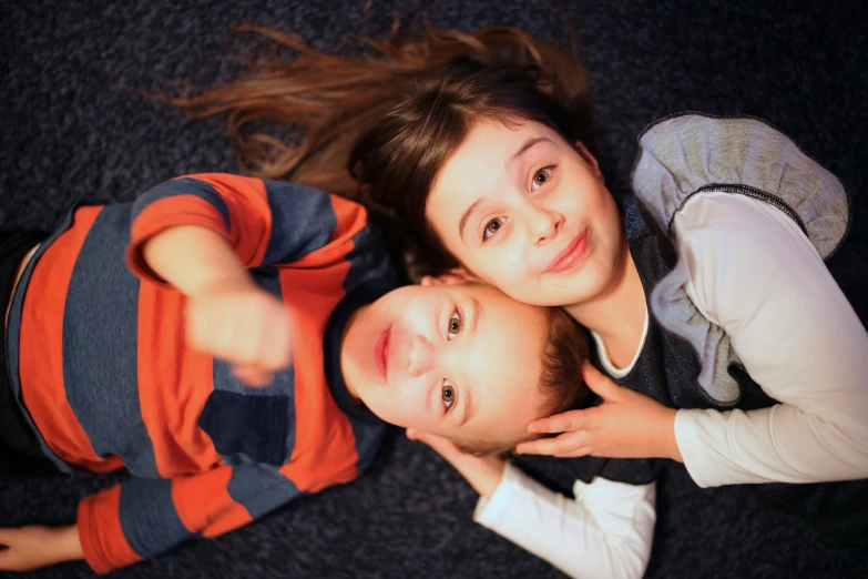 a woman sitting on a black carpet holding a little boy