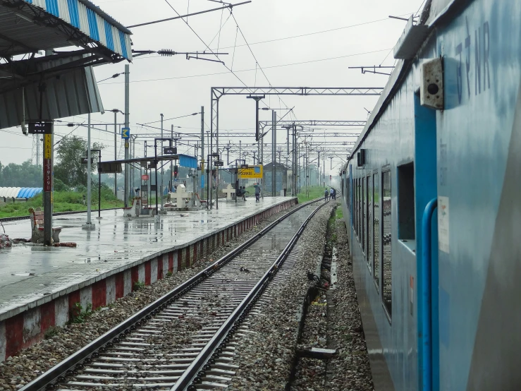 a train traveling down tracks next to a lush green field