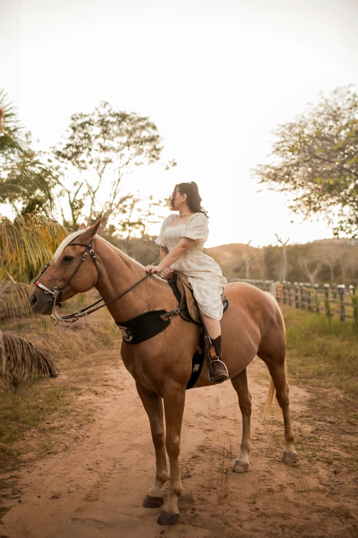 a woman is riding on a horse in the country