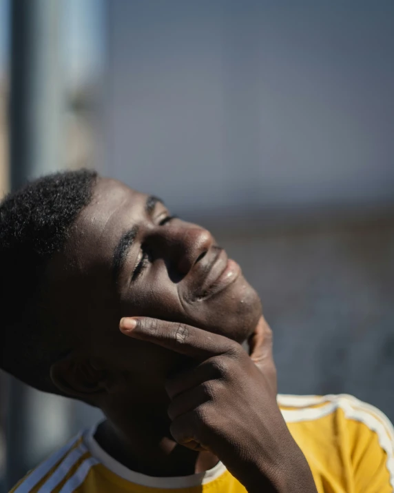  looking up with his hand to his face