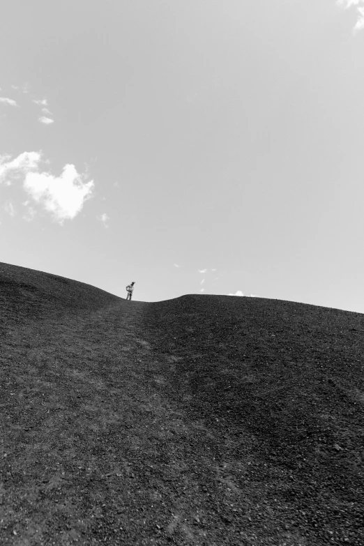 two people are flying kites on a hill