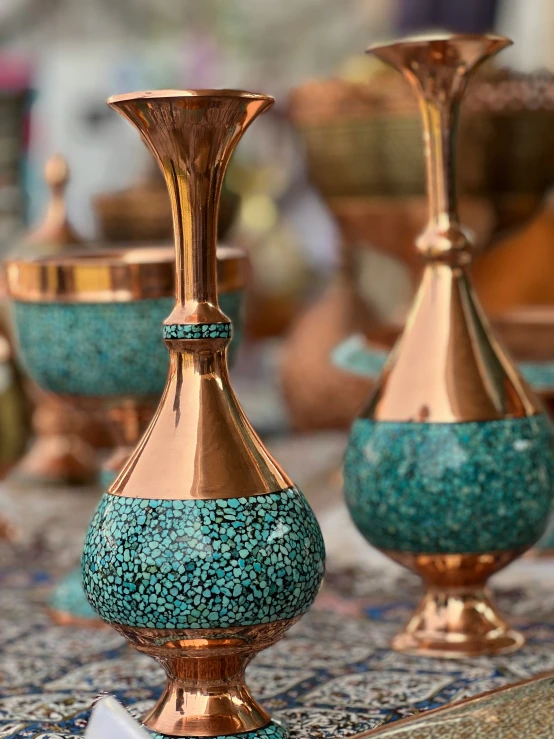 the three blue vases are on top of a floraly patterned tablecloth