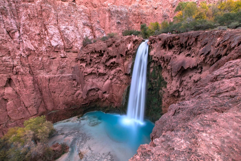 a blue pool in the middle of a large cave