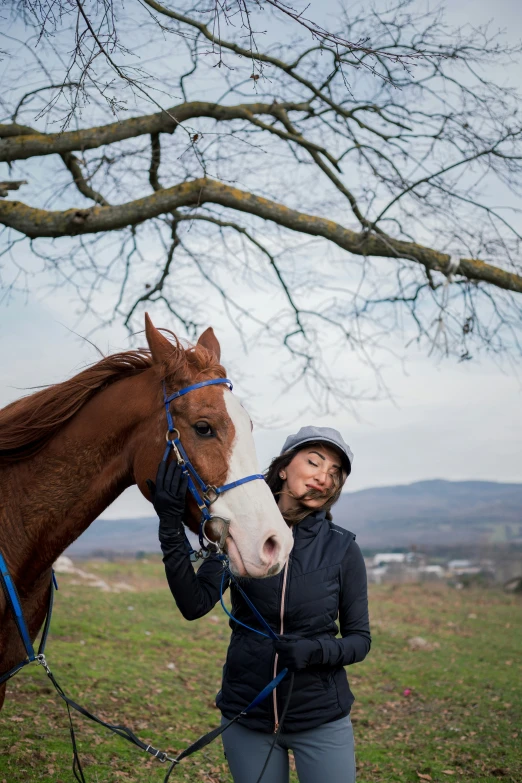 a woman holding the reigns of a brown horse