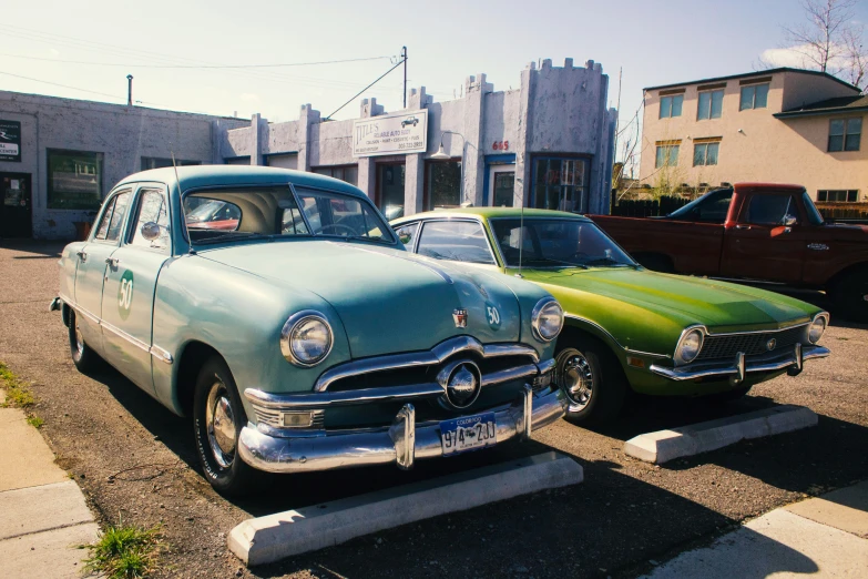 two vintage cars parked next to each other on the street