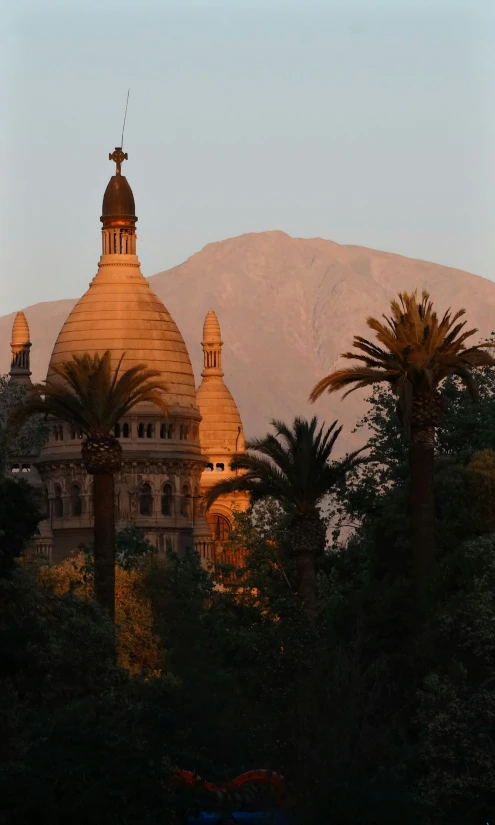 a view of mountains near an historic building and trees