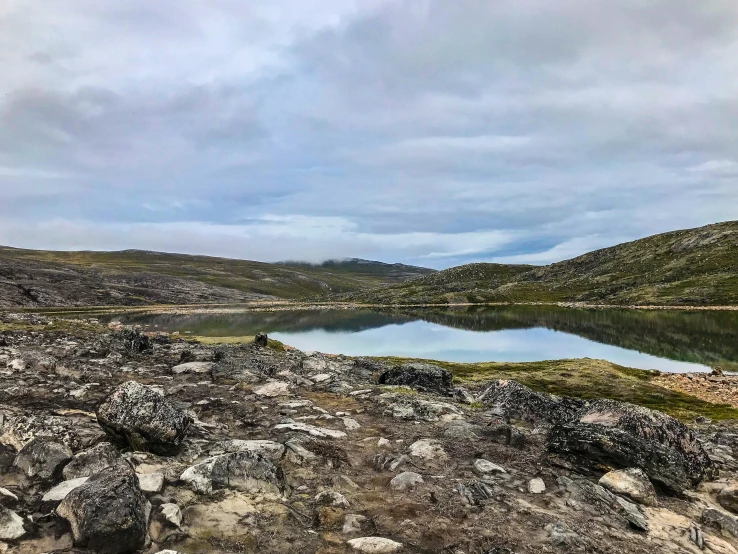 a body of water on the side of a rocky hillside