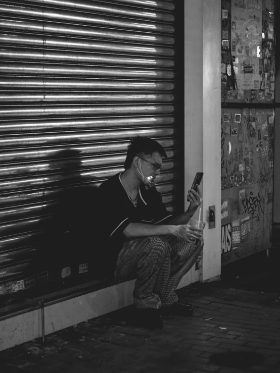 a woman sitting on a curb using a cell phone