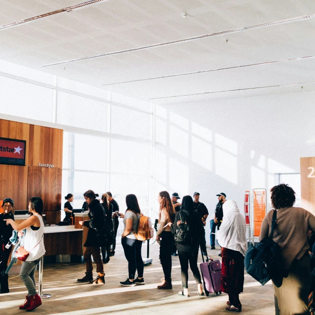 group of people standing in airport waiting to get on board