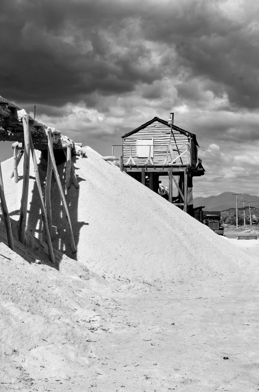 an old wooden house sits on the sand