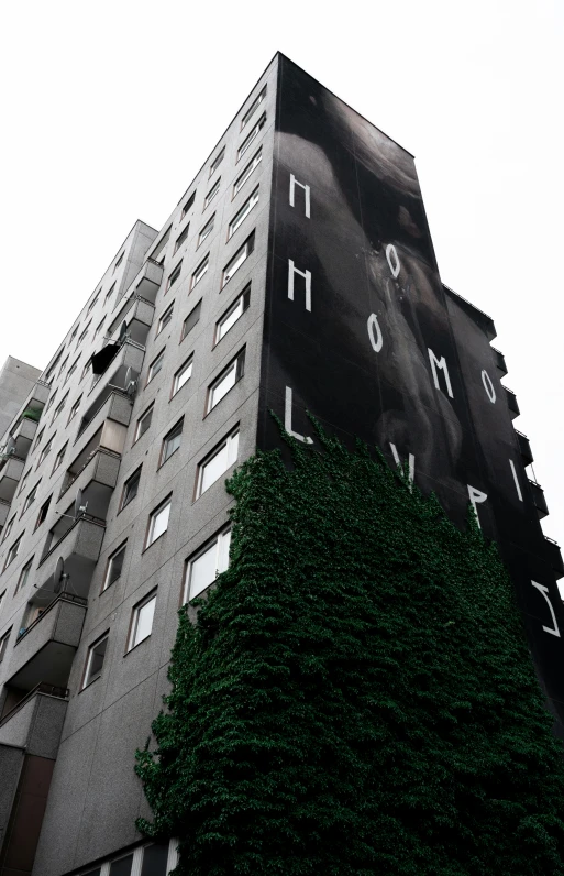 a giant building covered in greenery on top of a hill