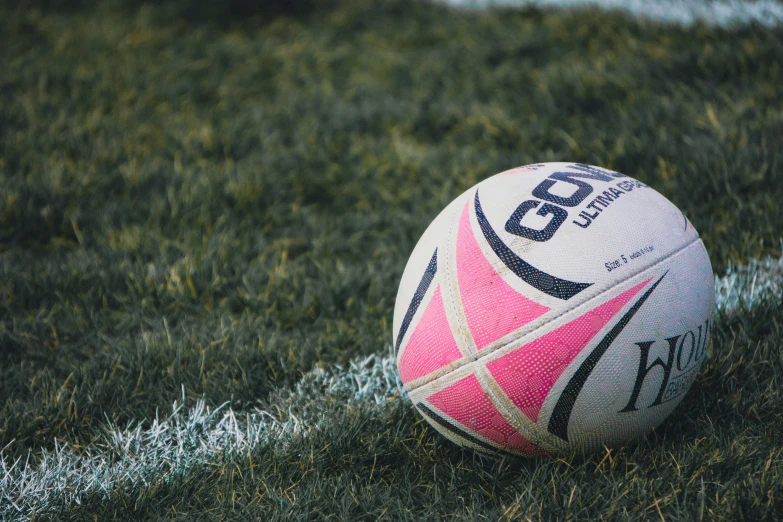 a rugby ball on the sidelines of a soccer field