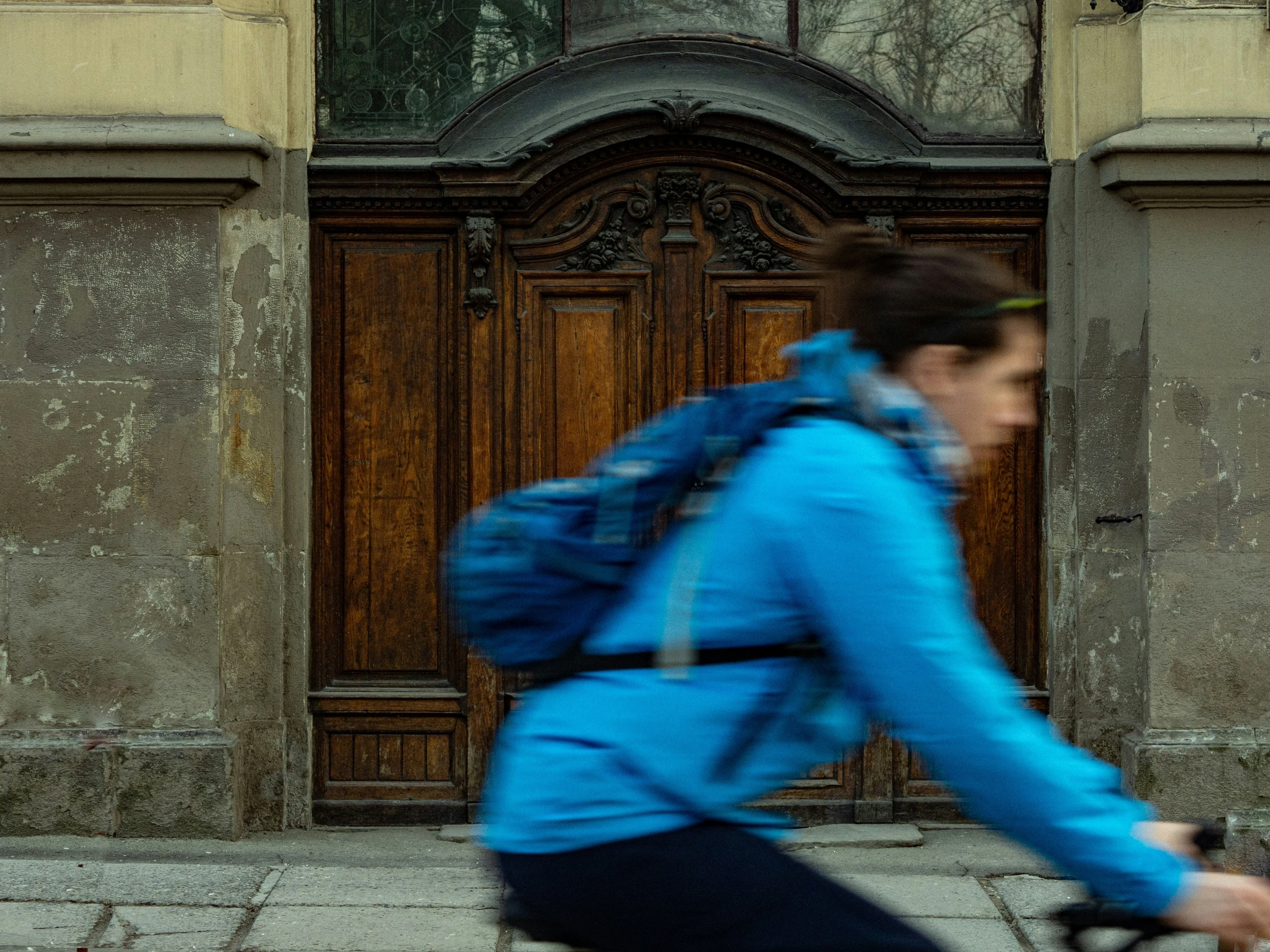 man riding on bicycle outside building, in front of doorway