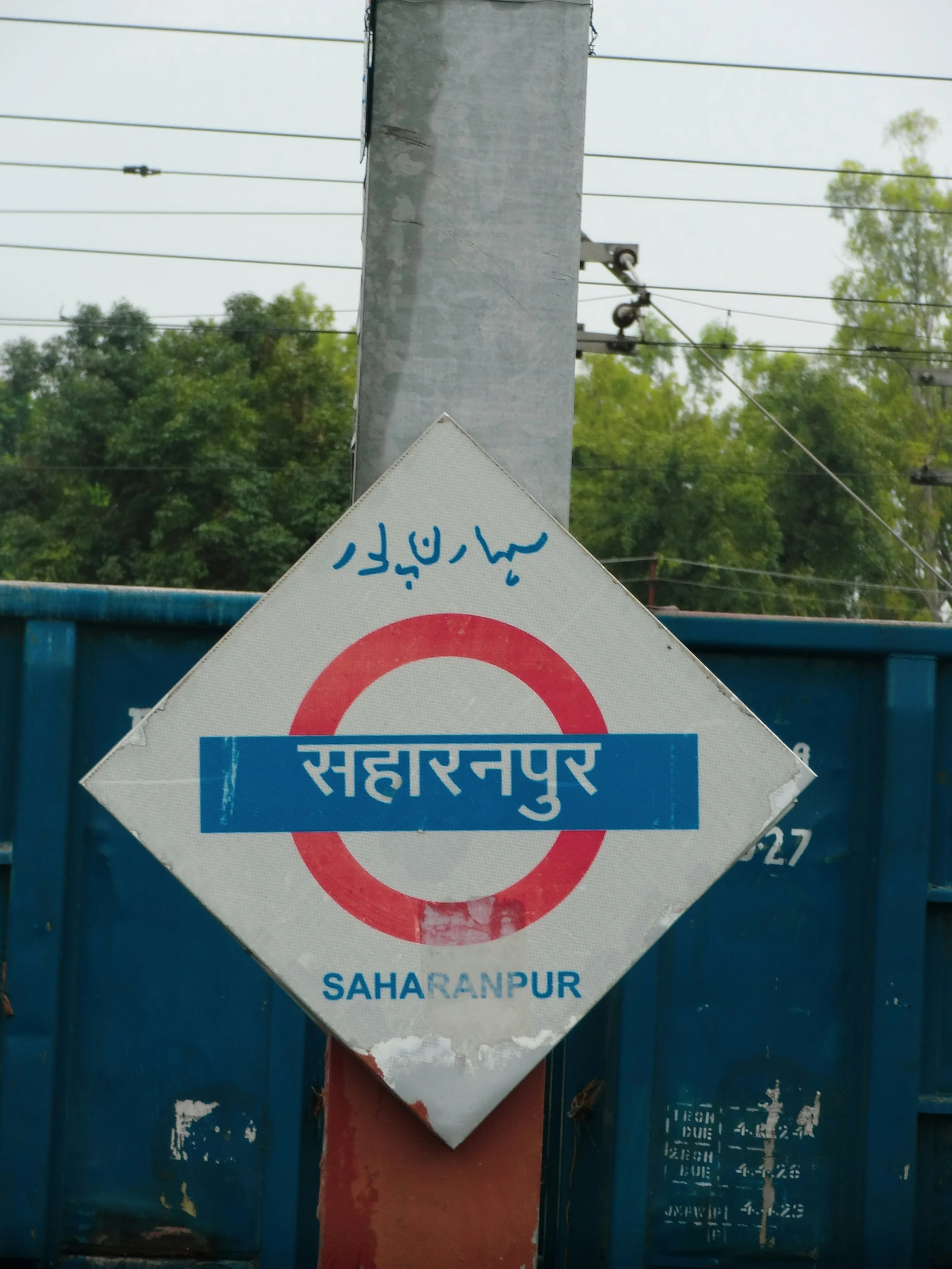 a sign that is sitting in front of a blue wall