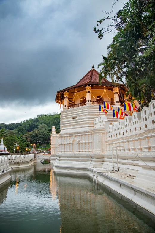 a temple near the water on a cloudy day